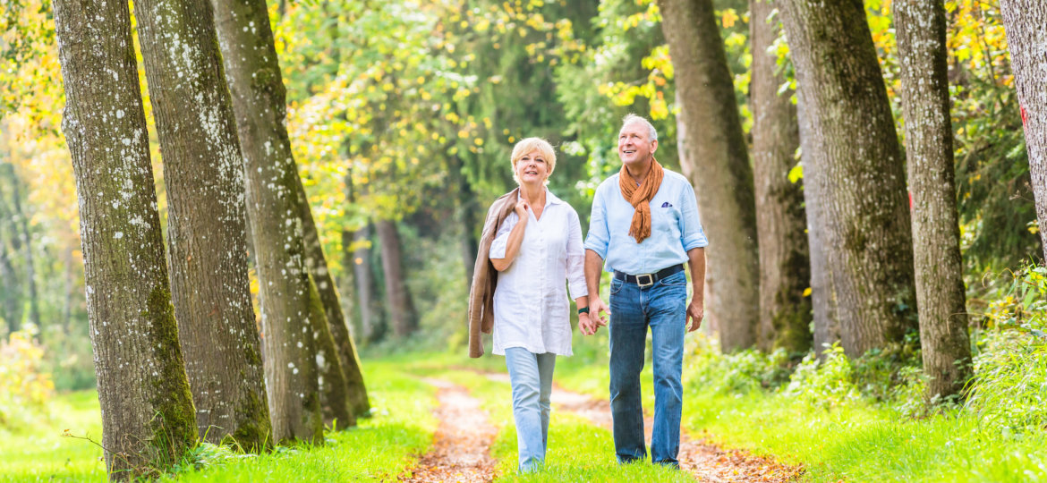 Senior couple having leisure walk in woods